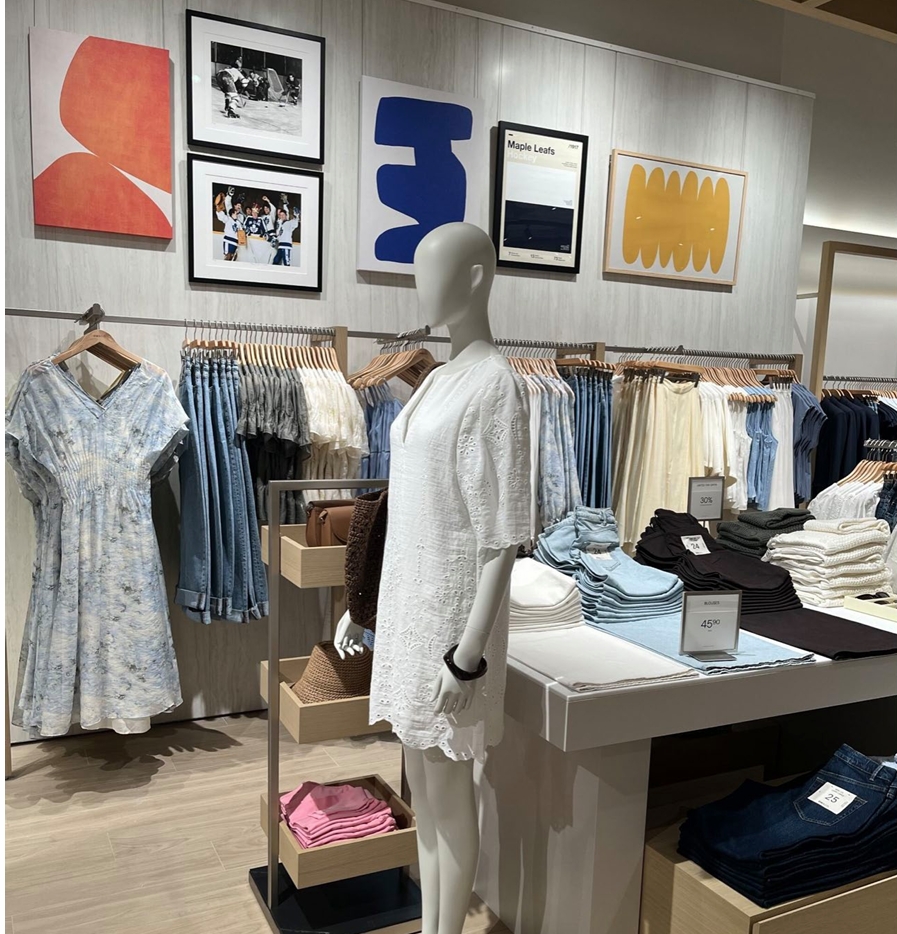 Retail display with art gallery wall and apparel racks