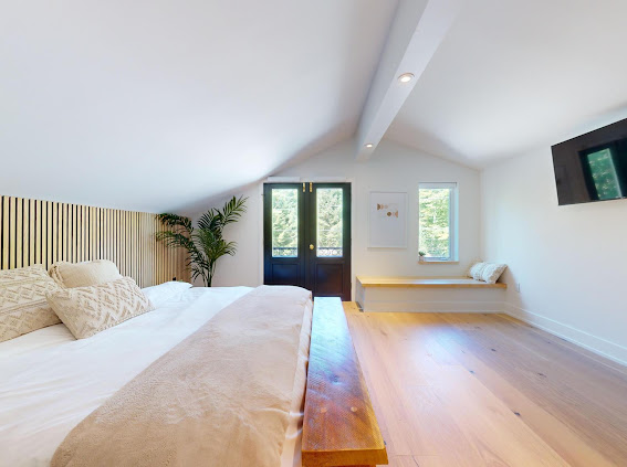 Loft bedroom with oak slat wall and garden doors